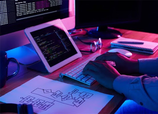 A developer\u2019s workstation with code on multiple screens